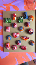 Afbeelding in Gallery-weergave laden, Kleurrijke bonbons op vrolijk bloemenpapier in de kleuren oranje en paars 
